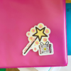 glitter sticker with pink and yellow magic wands on pink notebook, qr code on sticker plays song