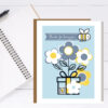 thank you card with flowers and qr that plays card on blue background seen on desk