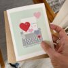 hand holding valentine and love card with hearts and typewriter, qr code that plays original love song