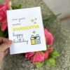 hand holding birthday card over bunch of flowers