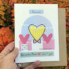 hand holding love card against colorful foliage
