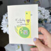 hand holding encouragement card with duck illustration and qr code that plays song