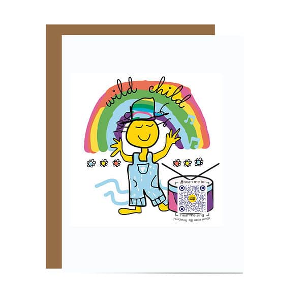 GC098 Wild Child Card Smiling character wearing rainbow colored hat and blue overalls near drum standing under rainbow with Wild Child typography in it